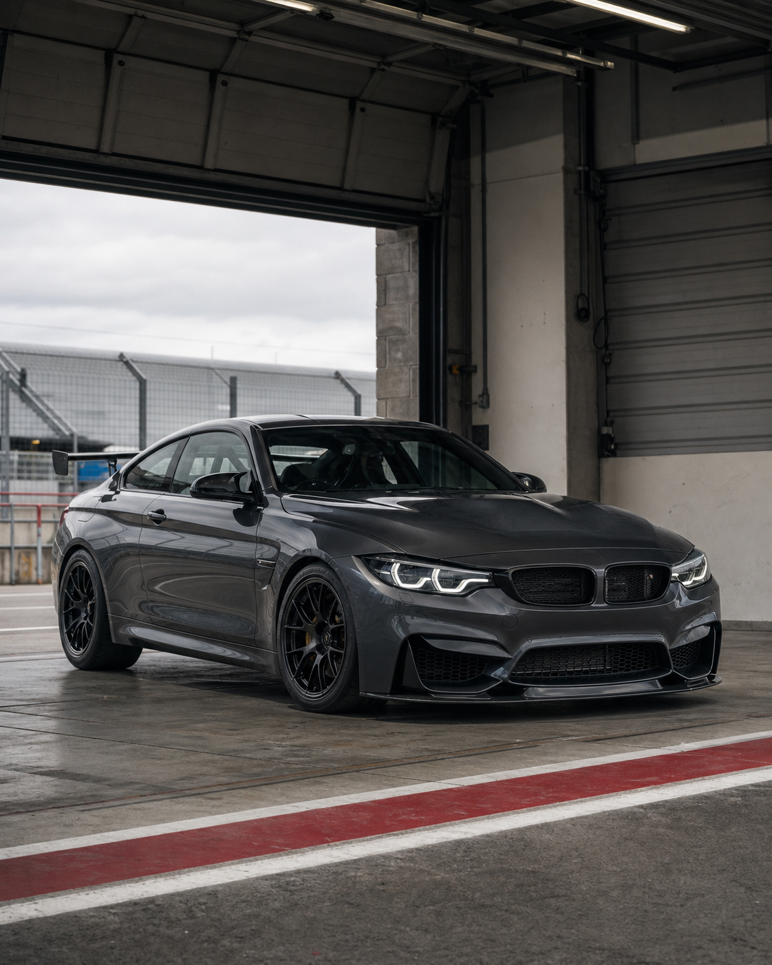 Graphite track-prepared sports coupe in a pit garage